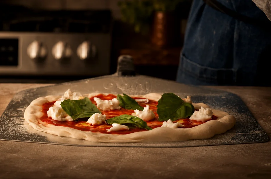 napolitansk pizza innan ugnsbakning toppat med tomatsås, ost och basilika